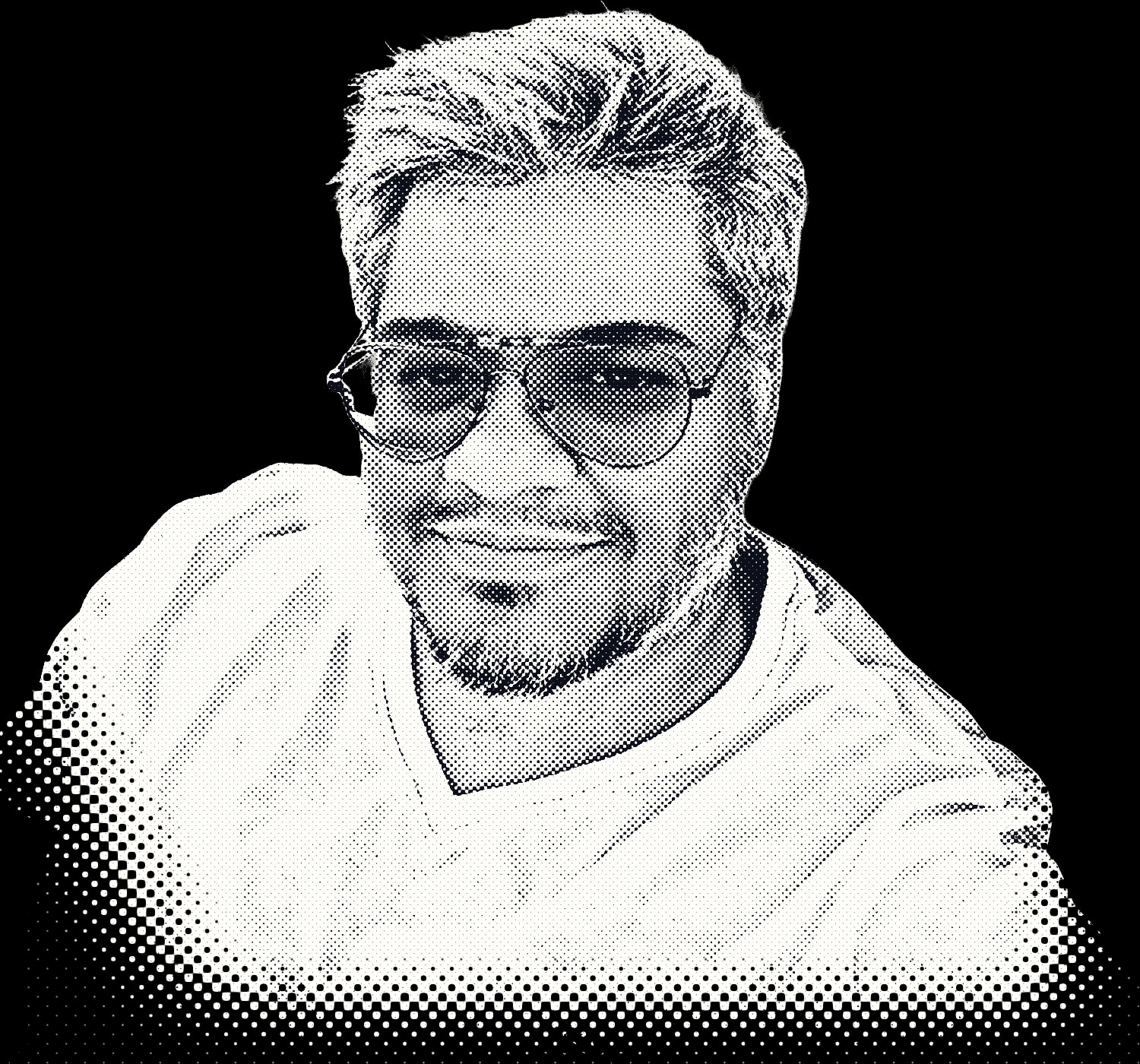 Sajan, smiling, in aviator glasses and a white T-shirt